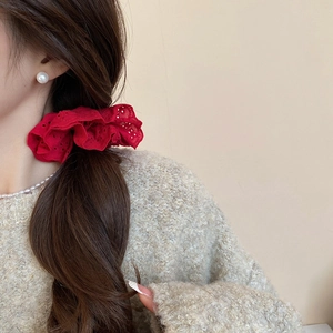 Detailed close-up of a red hollow lace scrunchie styled on a brunette ponytail