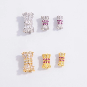 Macro detail of gold and silver cylinder beads with pavé-set red and white zircon stones