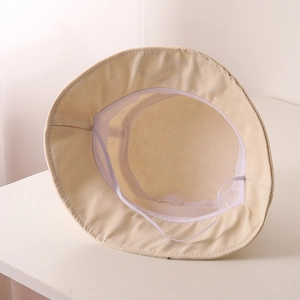 Vue détaillée de l'intérieur du chapeau bob beige avec mentonnière élastique et doublure
