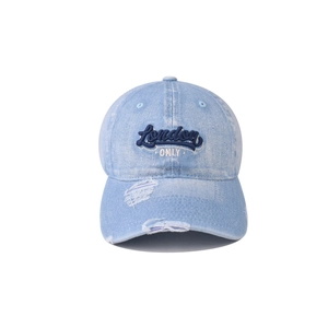 Detailed view of the distressed brim and London embroidery on the washed denim baseball cap