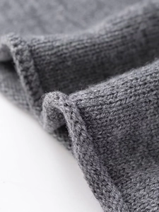 Close-up of fine knit dark grey wool texture and edge detail on a casual coat