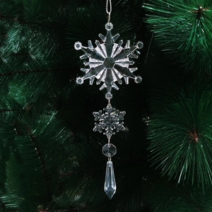 Macro shot of acrylic crystal snowflake ornaments hanging on a green Christmas tree
