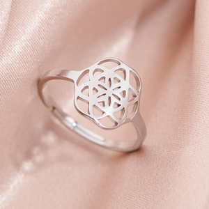 Silver hollow Flower of Life stainless steel open ring on soft pink silk background