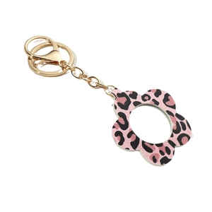 Flower-shaped pink leopard print PU leather keychain with gold hardware on white background