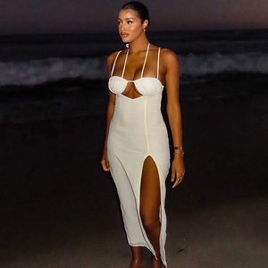 White halter neck maxi dress with side slit and backless design on a night beach