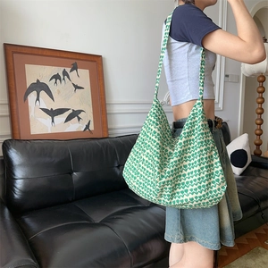 Detail of floral hobo bag with green tulip pattern on a model in a cozy living room