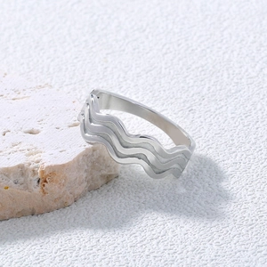 Detailed close-up of wavy silver stainless steel ring texture on white mineral stone