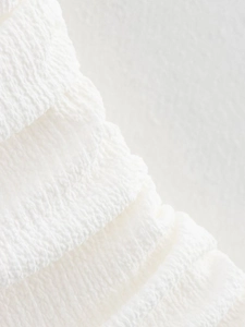 Macro detail of white seersucker fabric texture with soft pleated design for dresses