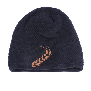 Detailed close-up of dark blue knit beanie featuring brown wheat embroidery texture