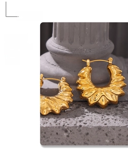 Detail of vintage 18k gold plated hollow flower earrings with wavy petal texture