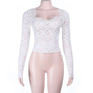 Détail du haut blanc à manches longues montrant les motifs de dentelle florale