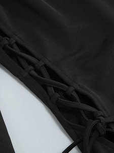 Detailed view of the side lace-up design on a black square neck long sleeve dress