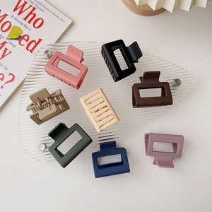 Flat lay of square matte hair claws in assorted candy colors on acrylic surface