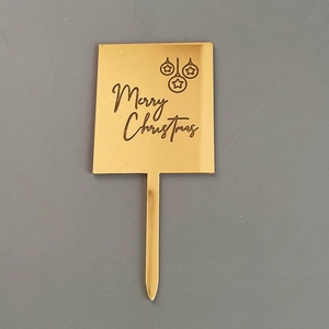 Vue de détail de topper de gâteau de Noël en acrylique miroir doré, décoration gravée.