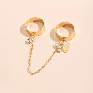 Detailed view of a gold chain ring bracelet with butterfly and rhinestone star pendants