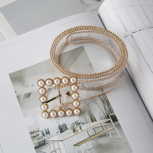 Detail of transparent PVC belt with gold bead trim and pearl-studded square buckle