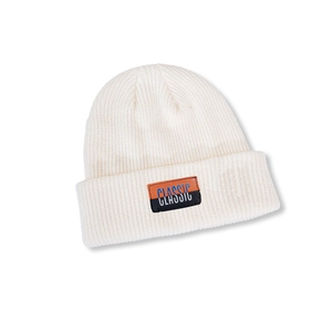 Detail of white ribbed knit beanie featuring a classic orange and black textile patch