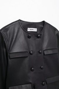 Close-up of matte black leather jacket collar with detailed stitching and brand label
