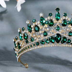 Macro shot of luxury gold bridal crown featuring emerald gemstones and white zircons