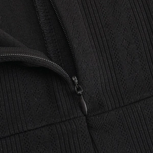 Close-up of invisible zipper and professional overlock stitching on black ribbed dress