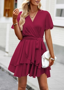 Détails d'une robe rose foncé avec col en V, manches à volants et ceinture nouée