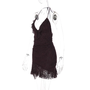 Détail d'une robe en dentelle noire avec licou, volants et texture froncée chic