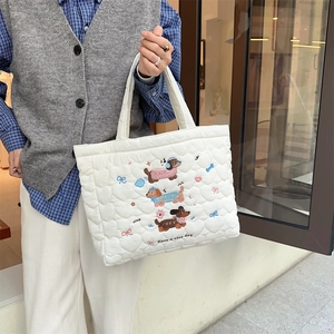Detailed view of quilted tote bag with cute sausage dog embroidery and heart patterns