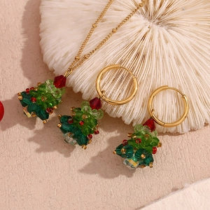Detail of Christmas tree jewelry set with green crystals and gold stainless steel finish