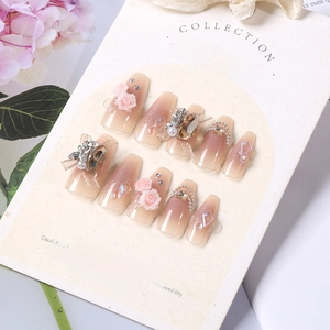 Macro shot of press-on nails with 3D pink roses, crystals, and delicate pearls