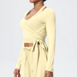 Detail of light yellow wrap top with V-neck and stylish waist tie for yoga set