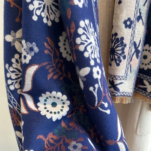 Detailed texture of dark blue floral pashmina scarf with soft fringe edges and patterns