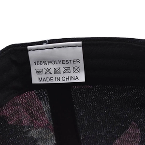 Close-up of the washing label on a 100% polyester baseball cap showing material details
