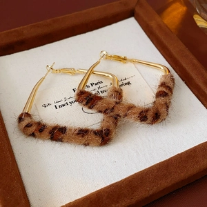 Dettaglio di orecchini a cerchio in peluche leopardato su un vassoio per gioielli