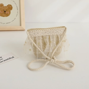 Détail d'un joli sac en paille pour enfant avec dentelle et tulle à pois brillants