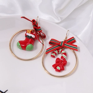 Detail of asymmetrical Christmas earrings with festive red sock and candy cane charms