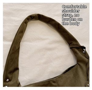Detail of wide comfortable shoulder strap on dark olive green suede crescent bag