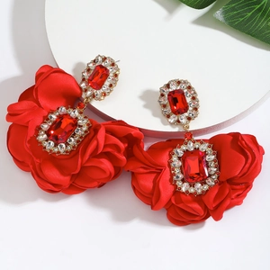 Detailed macro of red camellia earrings with large red crystals and gold metal base