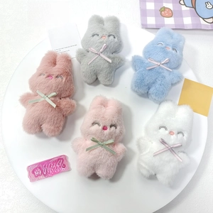 Gros plan de lapins en peluche colorés avec nœuds dans un plateau rond blanc