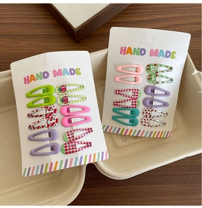Detailed set of ten colorful mini BB hair clips with fruit prints on display card