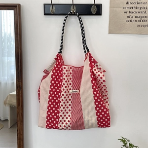 Détail du sac fourre-tout en toile à pois rouges et blancs avec étiquette de marque