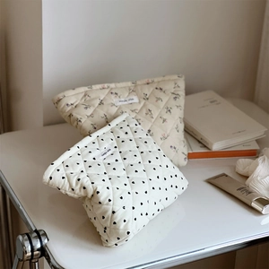 Detailed view of quilted cotton cosmetic bags with floral and heart print patterns