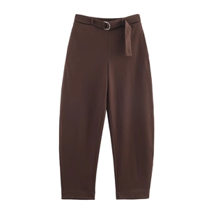 Detailed flat lay of dark brown velvet trousers featuring a matching belt with silver buckle