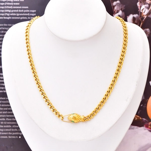Gold chunky Cuban chain necklace with emerald-eyed snake head clasp on a jewelry mannequin