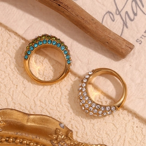 Close-up of gold plated stainless steel rings featuring blue and white rhinestone details
