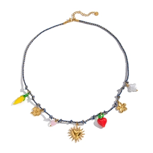 Detail of blue woven necklace with gold sun, heart, and chili charms on white background