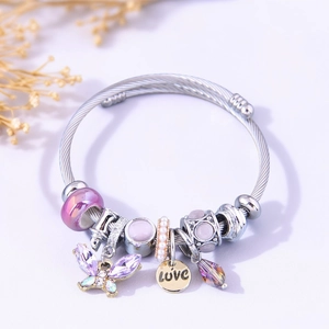 Detail of silver beaded bracelet featuring purple crystal butterfly and LOVE gold charm