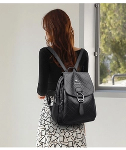 Gros plan d'un sac à dos en cuir noir matelassé montrant les détails de la fermeture