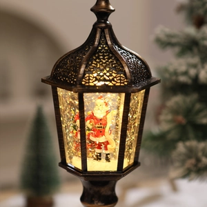 Close-up of vintage bronze Christmas lantern featuring snow globe with Santa and LED light
