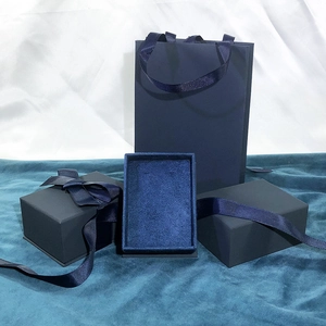 Detail of dark blue jewelry gift set with textured box, ribbon, and velvet insert