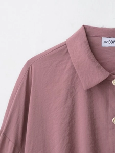 Detailed close-up of rose pink shirt collar and breathable fabric texture with white label